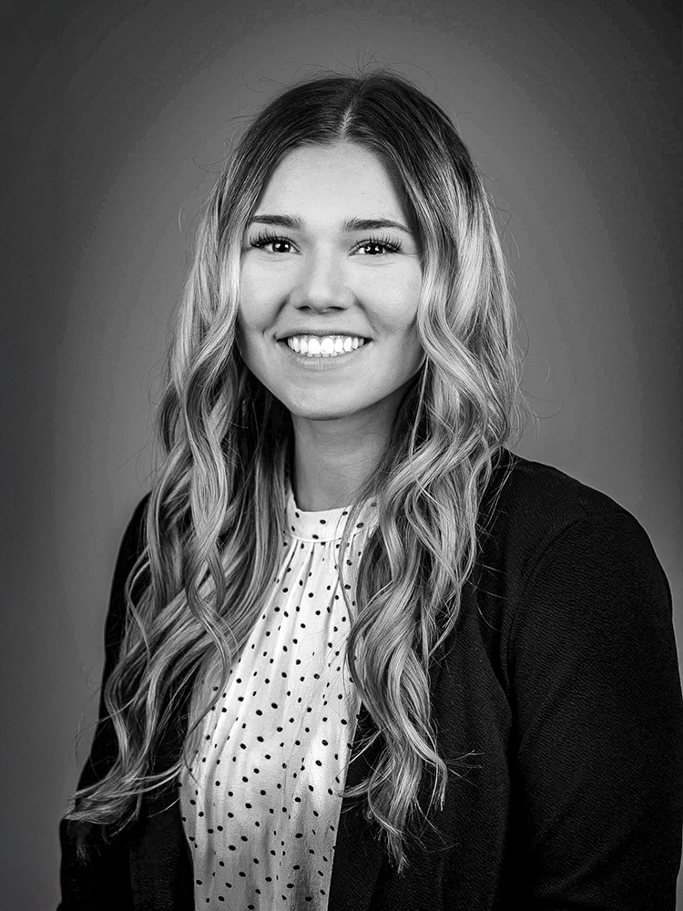 Abby Weber, a smiling women with long wavy hair and a polka-dot blouse.