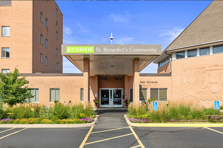Main entrance of Ecumen St. Benedict’s Community building with clear signage and accessible parking spots.